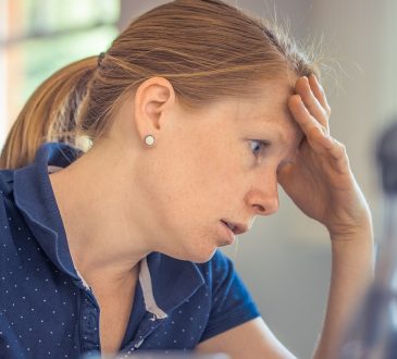 Infirmière en épuisement professionnel qui se tient la tête.
