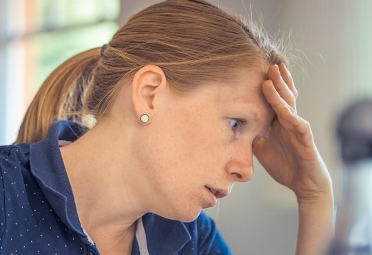 Infirmière en épuisement professionnel qui se tient la tête.