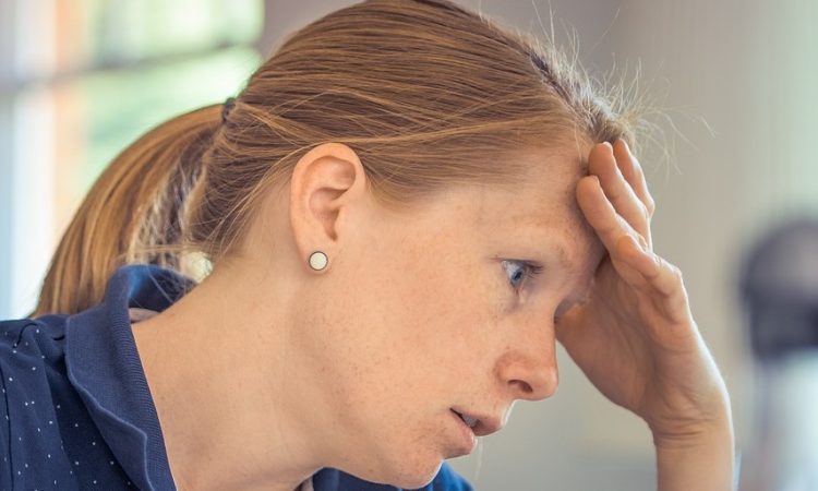 Infirmière en épuisement professionnel qui se tient la tête.