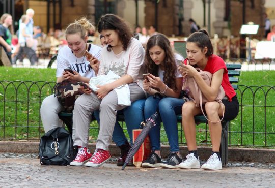 4 adolescentes qui regardent leur cellulaire
