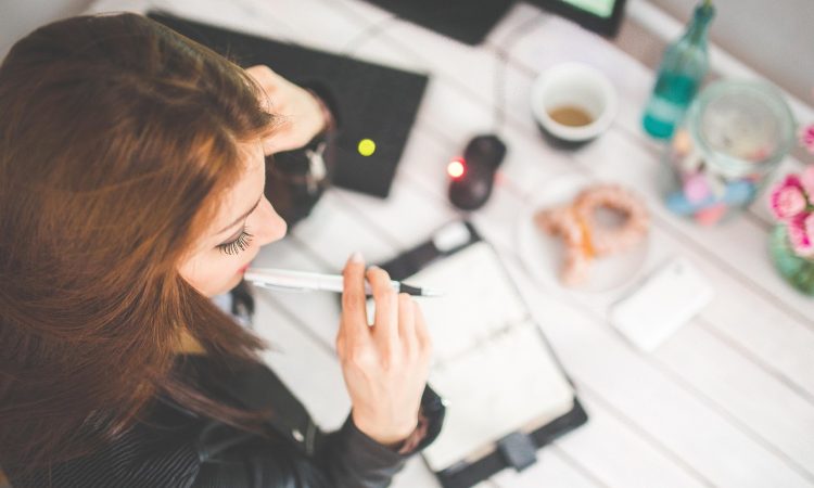Femme au travail qui réfléchie